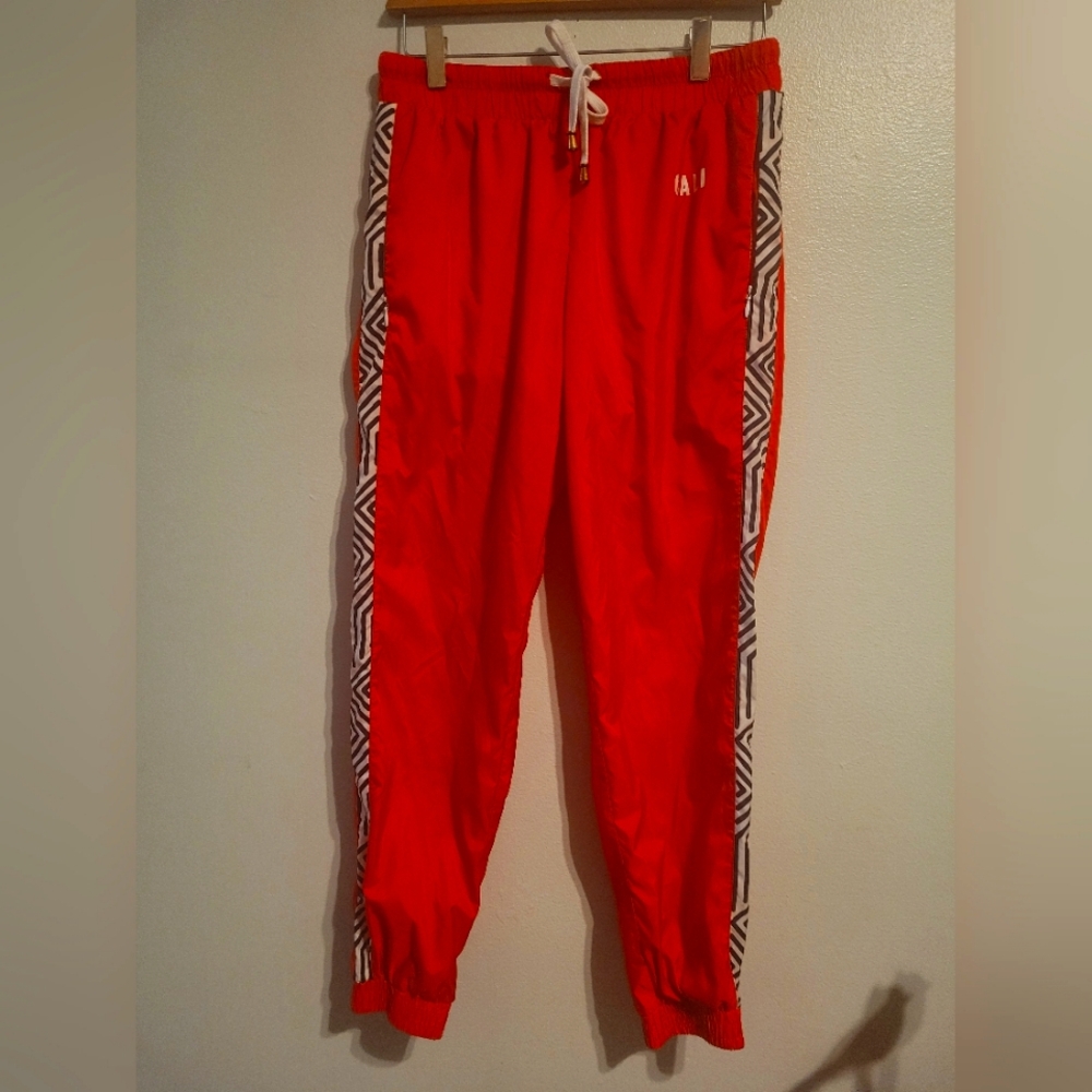 Red Track Pants with Geometric Side Stripes.